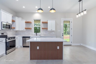 Kitchen featuring open shelves, backsplash, finish