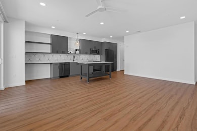 Living room with light wood finished floors, recessed lighting, and ceiling fan