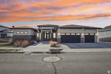 Prairie-style house with stone siding, stucco siding, an attached garage, and concrete driveway