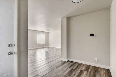 Unfurnished room featuring wood finished floors and a textured ceiling