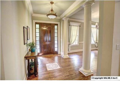 Foyer features custom inlaid mosaic tile and large columns introducing guests to the Formal Dining room.