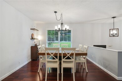 Dining room featuring a chandelier, hardwood / wood-style flooring, and baseboards
