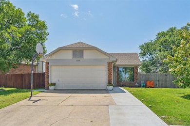 View of front of house featuring brick siding, driveway, an attached garage, and roof with shingles