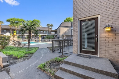 Property entrance featuring a community pool, fenc