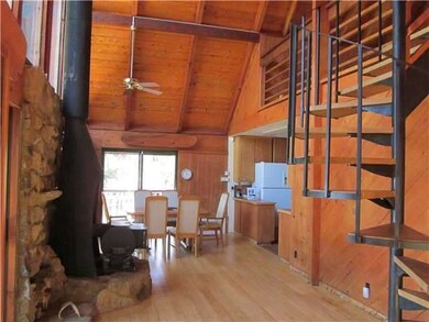 Large rock surrounding wood burning stove. Vaulted