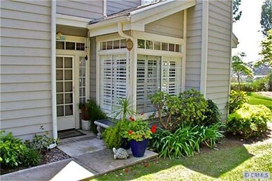 Welcoming front porch is surrounded with lovely pl