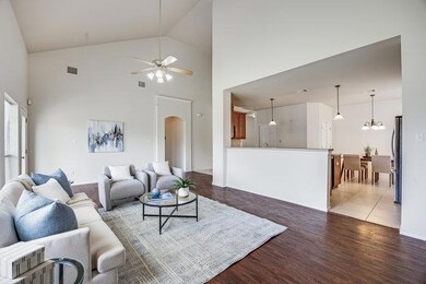 Living room featuring arched walkways, ceiling fa