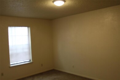 Spare room with dark carpet and baseboards