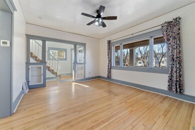 Spare room featuring light wood-style flooring, baseboards, stairway, and plenty of natural light