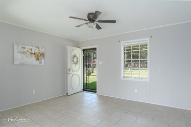 Tiled spare room with crown molding and ceiling fa