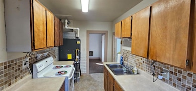 Kitchen featuring tasteful backsplash, white electric range oven, and brown cabinets