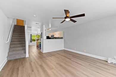 Unfurnished living room with ceiling fan, stairwa