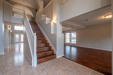 Staircase with a textured ceiling and wood-type fl
