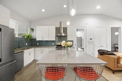 Kitchen with wall chimney range hood, concrete fl