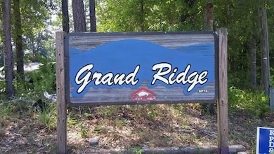 Community sign featuring view of wooded area