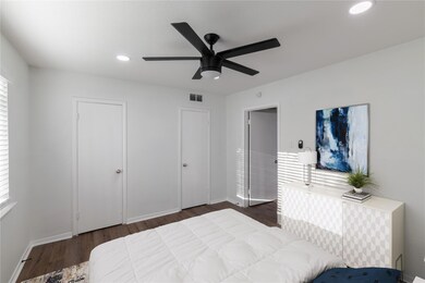 Bedroom with wood finished floors, baseboards, vis