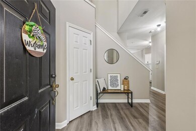 Foyer featuring wood finished floors, baseboards, and stairway