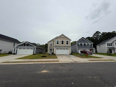Craftsman-style home featuring concrete driveway, board and batten siding, and a garage