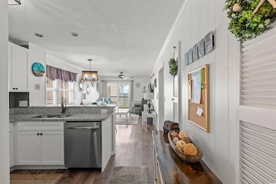 Kitchen with white cabinets, dark wood-type floori