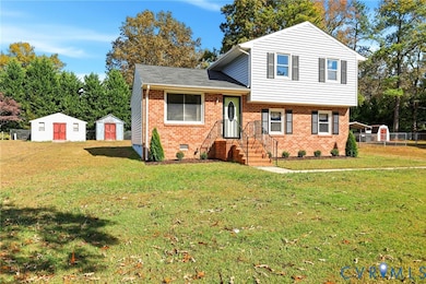 Tri-level home with a storage unit, brick siding, crawl space, and a shingled roof