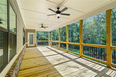 Wooden terrace featuring a ceiling fan and view of wooded area