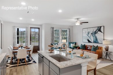 Kitchen featuring light stone countertops, ceiling fan, light wood-type flooring, and sink