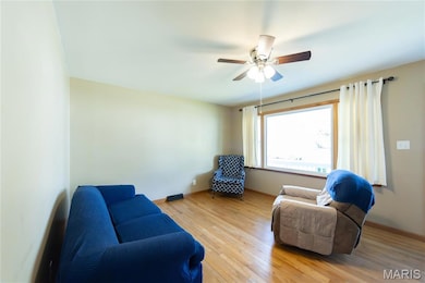 Living area with light wood-style flooring and ceiling fan