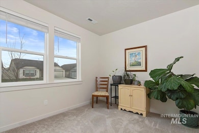 Living area featuring light colored carpet and baseboards