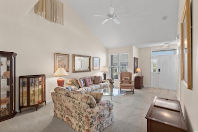 Living area featuring carpet floors, a ceiling fan