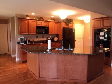 The Open Kitchen plan has island with Kitchen Sink, Granite Coutertops,  Cooktop and Double wall Ovens.  Has Large Pantry.  Custom Cherry Cabinets. with pot and pan drawers and lots of cabinet space.  French Doors leading out to Covered Patio 