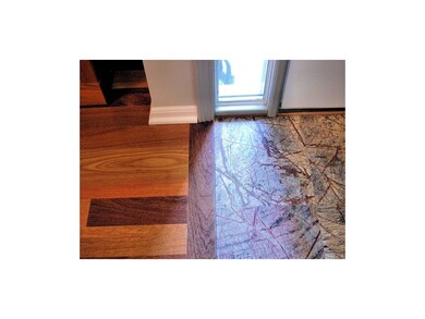 Marble tile entry and teak wood living room floor