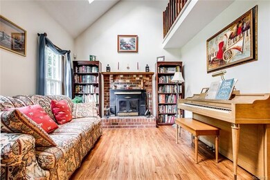 Living room with vaulted ceiling, skylights, wood 
