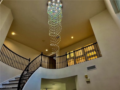 Staircase with recessed lighting, a chandelier, an