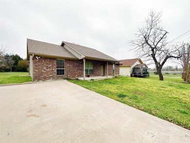 Ranch-style home featuring a garage, a trampoline, and a front lawn
