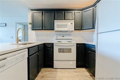The kitchen has quartz counter tops, white tile ba