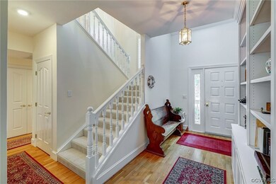 Wood floored foyer entrance featuring an inviting