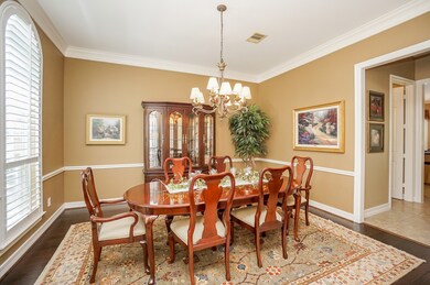 Rich, engineered wood floors provide the perfect canvas for this charming formal dining area, naturally lit and surrounded with sophisticated earth tones and wall detail.