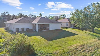 Rear view of house with a lawn, a sunroom, and cen