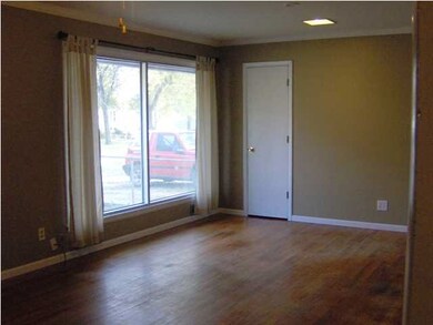 Living Room has large picture windows and hardwood