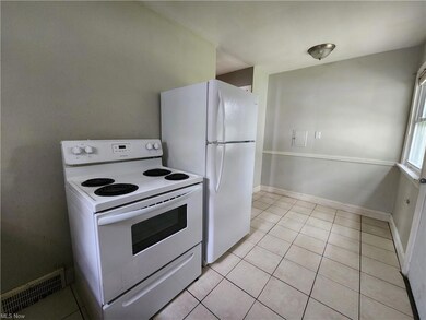 Kitchen with white electric range and light tile f