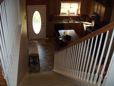 Top of Staircase with Open View of Kitchen, Dining Area and Living Roomw