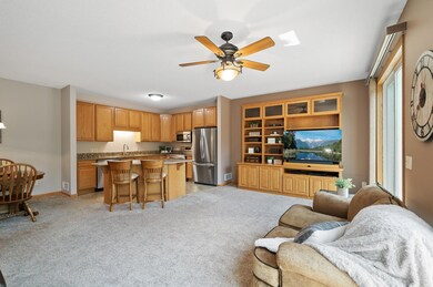 Light, bright and open living room featuring a custom built in cabinet, ceiling fan and walk-out to the deck.