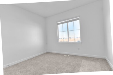 Empty room with light colored carpet and baseboards