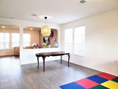 Kitchen with wood finished floors and decorative light fixtures