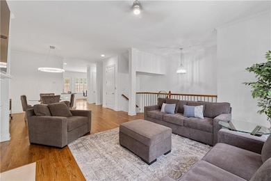 Living area featuring wood finished floors, recessed lighting, ceiling fan, and a chandelier