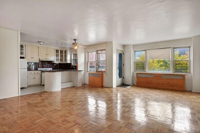 Kitchen featuring open floor plan, a peninsula, decorative backsplash, freestanding refrigerator, and glass insert cabinets
