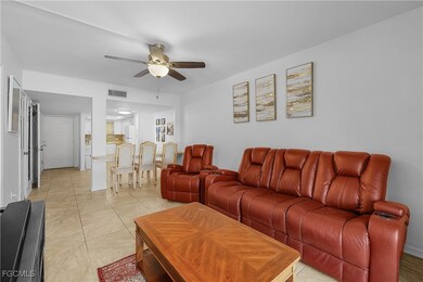 Living area with a ceiling fan and light tile patterned floors