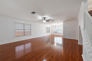 Spare room with stairway, ceiling fan, dark wood-
