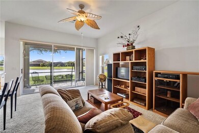 Carpeted living room with ceiling fan
