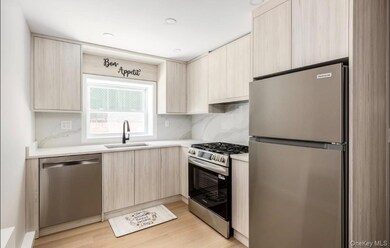 Kitchen with appliances with stainless steel finishes, light brown cabinets, modern cabinets, and tasteful backsplash